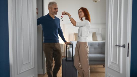 Gastvrouw ontvangt iemand in een vakantieverblijf