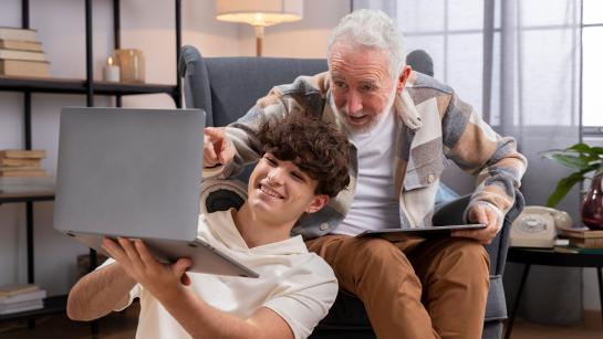 sfeerbeeld, oudere en jonge man kijken samen op een laptop