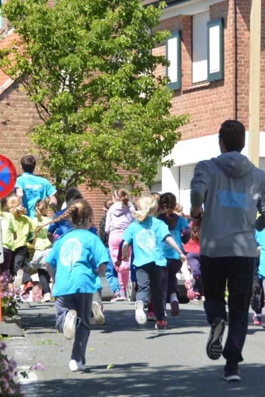 Groep kinderen die onder begeleiding lopen op straat