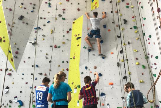 Groep jongeren op de klimmuur.
